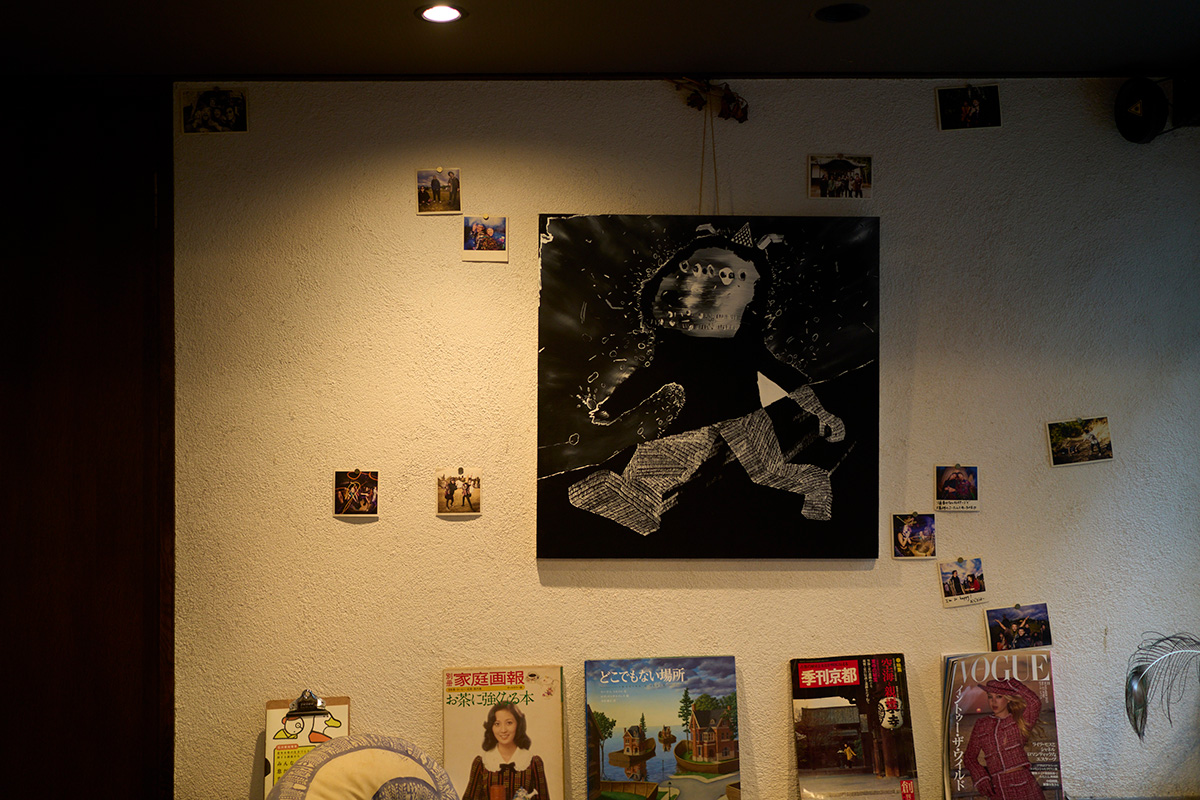 A wall in Ariya’s home is decorated with magazines, artwork, and photos with her friends.